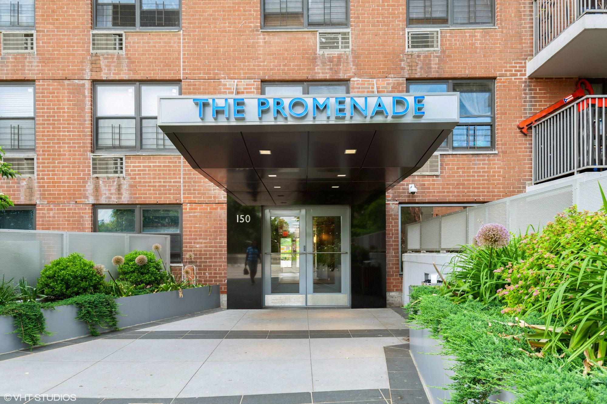 The Lobby entrance of The Promenade, located at 150 West 250th Street, as seen from the entry walkway.
